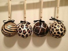 three ornaments are hanging on the wall with black and white stripes, leopard print ornament