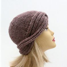 a mannequin head wearing a knitted hat on top of a white background