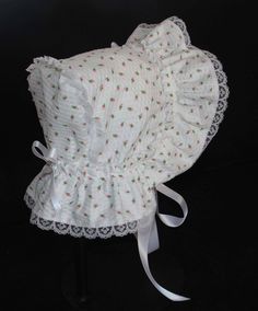 A beautiful Victorian style baby bonnet. Fabric is white searsucker with rosebuds. Lining is white . Bonnet has an extended back and is trimmed with white lace. Bows and extra long ties are made of white double sided satin ribbon. Size/ Measurement from under ear lobe around top of head to under other ear lobe preemie / 10 inches 0-3 months / 11 inches 3-6 months / 12 inches 6-9 months / 13 inches 9-12 months / 14 inches 12-18 months/ 15 inches Fitted White Bonnet With Lace Trim, Cute Fitted White Bonnet, Cute White Fitted Bonnet, Adjustable Cotton Bonnet With Lace Trim, White Fitted Vintage Bonnet, Fitted Cotton Bonnet With Lace Trim, White Fitted Hat With Lace Trim, White Cotton Bonnet For Spring, Spring White Cotton Bonnet