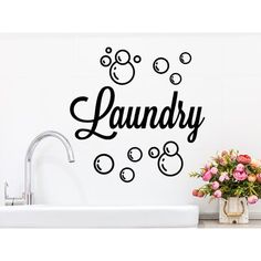 a bathroom wall decal with the word laundry written in black on it next to a sink