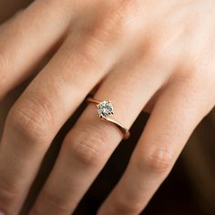 a woman's hand with a diamond ring on top of her finger, showing the center stone