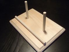 two wooden pegs sitting on top of each other in front of a black surface