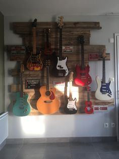 several guitars are hanging on the wall