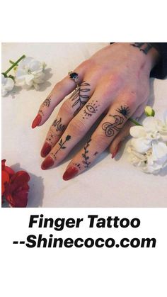 a woman's hand with tattoos on it and flowers around the ring finger area