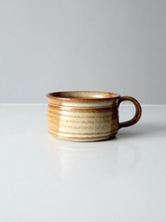 a brown and white cup sitting on top of a table