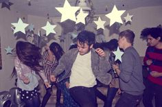 a group of young people dancing in a room with stars on the ceiling