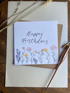 a happy birthday card with flowers on it next to some scissors and other crafting supplies