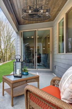 an outdoor patio with wicker furniture and large glass doors leading to the back yard