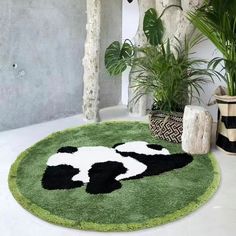 a black and white soccer ball on a green area rug next to potted plants