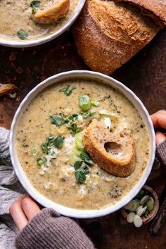 two bowls of soup with bread on the side