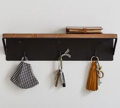 three keys hang on a shelf with two books and some other items hanging from it