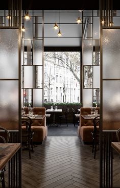 the interior of a restaurant with wooden tables, chairs and glass partitions on the walls