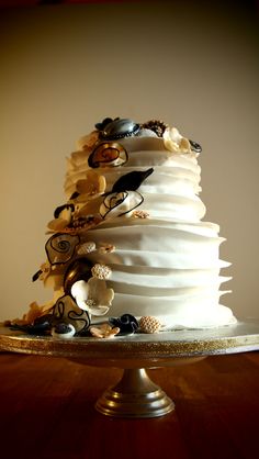 a wedding cake with white frosting and gold decorations