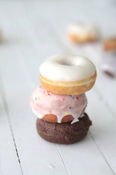 three donuts stacked on top of each other with frosting and sprinkles