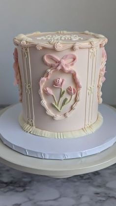 a pink cake decorated with flowers and bows