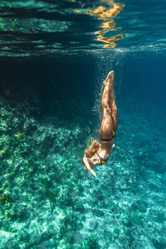 a man swimming in the ocean with his head above the water's surface as he dives