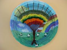 a paper plate that has been made to look like a tree with rainbows on it