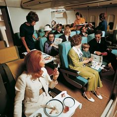 people sitting in seats on an airplane eating and reading books while others look at them