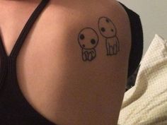 a woman with two small tattoos on her shoulder