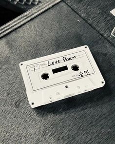 an old white cassette with the words love poem written on it sitting on a table