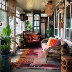 a porch with wicker furniture and potted plants on the side wall, along with large windows