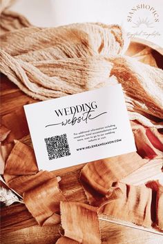 a business card sitting on top of a pile of wood pieces with the word wedding written in black ink