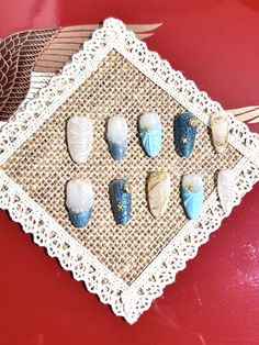 seven seashells are placed on a doily next to an owl figurine