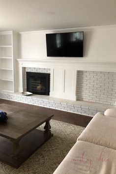 a living room with two couches and a flat screen tv mounted above the fireplace