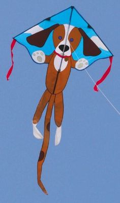 a brown and white dog kite flying in the sky