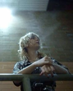 a woman standing next to a metal railing