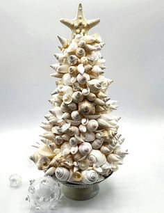 a christmas tree made out of seashells on a white background with an ornament