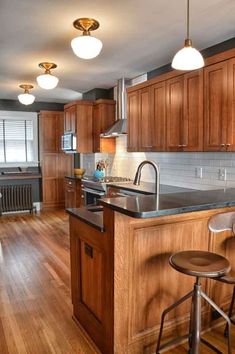 a kitchen with wooden cabinets and black counter tops