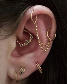 a woman wearing three different types of ear piercings