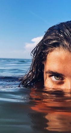 a woman with wet hair swimming in the ocean