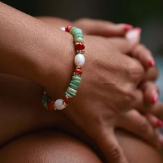 This handmade boho stretch bracelet is meticulously crafted using  natural beauty of green mother-of-pearl heishi discs, 4 pieces of 8 mm real rice pearls, 16 pieces of 14k gold plated hematite, and 8 pieces of red coral stones. Eight pieces of red coral stones are carefully placed between the hematite stones. Each coral stone carries a sense of energy and vitality, adding a touch of passion and warmth to the bracelet. This adjustable statement bracelet is designed for versatility and comfort. It features an adjustable stretch design, allowing it to effortlessly fit a range of wrist sizes. You can use this summer bracelet without removing from your wrist all day long. You can take a shower, swim in the sea or do whatever you like while wearing it. It is not only beautiful but also eco-frie Bohemian Stretch Bracelet With Natural Stones, Handmade Green Beaded Bracelets For Holidays, Bohemian Round Bead Bracelets For Holiday, Adjustable Green Beaded Bracelets For Holiday, Bohemian Style Stretch Bracelet Gift, Green Stretch Bracelet With Colorful Beads, Handmade Green Bracelets For Holiday, Hand-strung Bohemian Stretch Bracelet, Bohemian Hand-strung Stretch Bracelet For Vacation