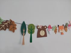 some paper animals and trees hanging on a line