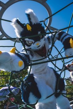 several stuffed animals are stuck in a cage at an amusement park as people look on