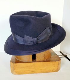 Here for your consideration this beautiful blue fedora made from all vintage recycled parts. I just could not throw any of this away. Assembled using all vintage parts, felt, leather sweatband, ribbon and lining come from scrap hat pieces. Appears as a stylish fedora with added wide ribbon. Beaver felt feels dense and of high quality. By no means is this perfect but shows well and can always be upgraded. Felt does show imperfections, nothing serious but not perfect. Please view photos as they are part of the description.  Comes in a size 7 1/8 as marked. Approximate brim at 2 1/2 + inches and Crown is just shy of 5 1/2 inches tall.  Blue hats are not that common so I'm glad I was able to save all these recycled hat pieces to make this one. Please view photos as they are part of the descrip Formal Blue Winter Hat, Blue Formal Winter Hat, Vintage Blue Hat With Flat Brim, Vintage Blue Adjustable Hat Bands, Vintage Wool Cloche Hat, Vintage Fitted Wool Fedora, Vintage Blue Short Brim Hat, Vintage Blue Flat Brim Hat, Vintage Wool Hat Bands With Flat Brim