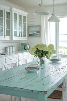 a dining room table with plates and vases on it