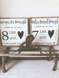 two signs are sitting on a bench in front of a white wall and brick floor