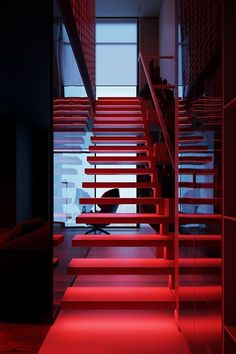 red stairs leading up to the top floor in a room with dark walls and floors