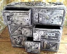 an old wooden dresser with many drawers and clocks on it's sides, sitting on top of a table