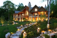 a large house with stone steps leading up to the front door and landscaping area at night