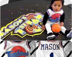 a little boy sitting on top of a basketball uniform