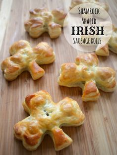 small cross shaped biscuits sitting on top of a wooden cutting board with the words shamrock shaped irish sausage rolls