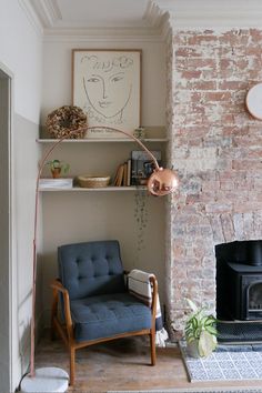 a living room with a brick fireplace and blue chair