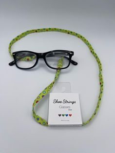 "B. Odd💜B. Bold💚B. Unique💙B. You❤️B. Happy Shoe Strings Glasses Laces are handmade from cotton fabric in various beautiful prints.  Spice up your eyeglasses with our glasses laces and show the world your own unique style! Each of our Glasses Laces have adjustable silicon rings that just slip into your glasses and fit all sorts of, reading glasses, prescription glasses and sunglasses.  Each lace is approximately 30\" in length.  PLEASE NOTE:  Laces are cut from the same fabric as pictured, but may differ in looks due to how the fabric is printed and cut.  If you have any questions or requests please contact us. Glasses and other display items not included in listing." Adjustable Green Glasses Chain For Gift, Adjustable Green Glasses Chains For Gifts, Adjustable Green Glasses Chain As Gift, Trendy Green Glasses Chains As Gift, Silicon Rings, Glasses Prescription, Happy Shoes, Rainbow Polka Dots, Glasses Chains