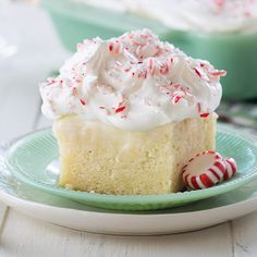 a piece of cake with white frosting and candy canes on a green plate