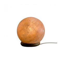 an orange ball lamp sitting on top of a wooden base with a wire attached to it