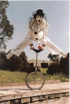 a clown riding on top of a unicycle